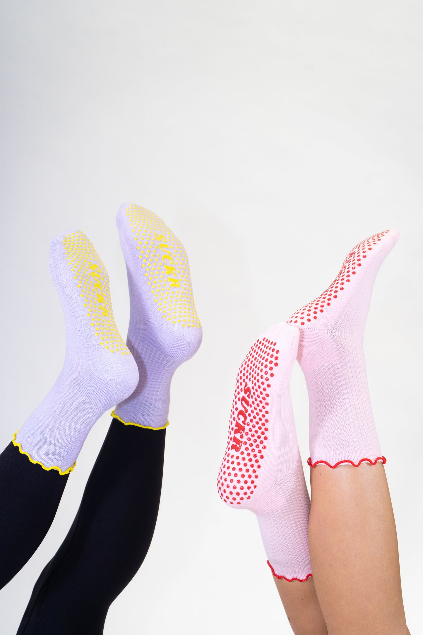 SUCKR princess frill purple and pink gripsocks, feet in the air